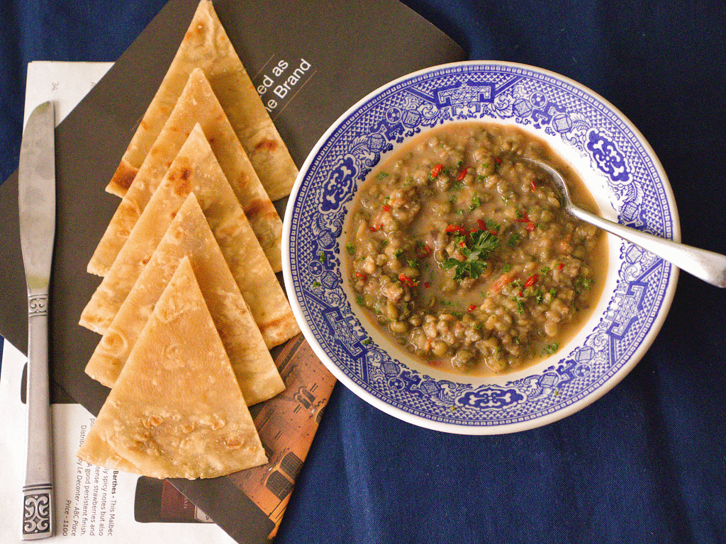 cooked lentil with bread on a table.
